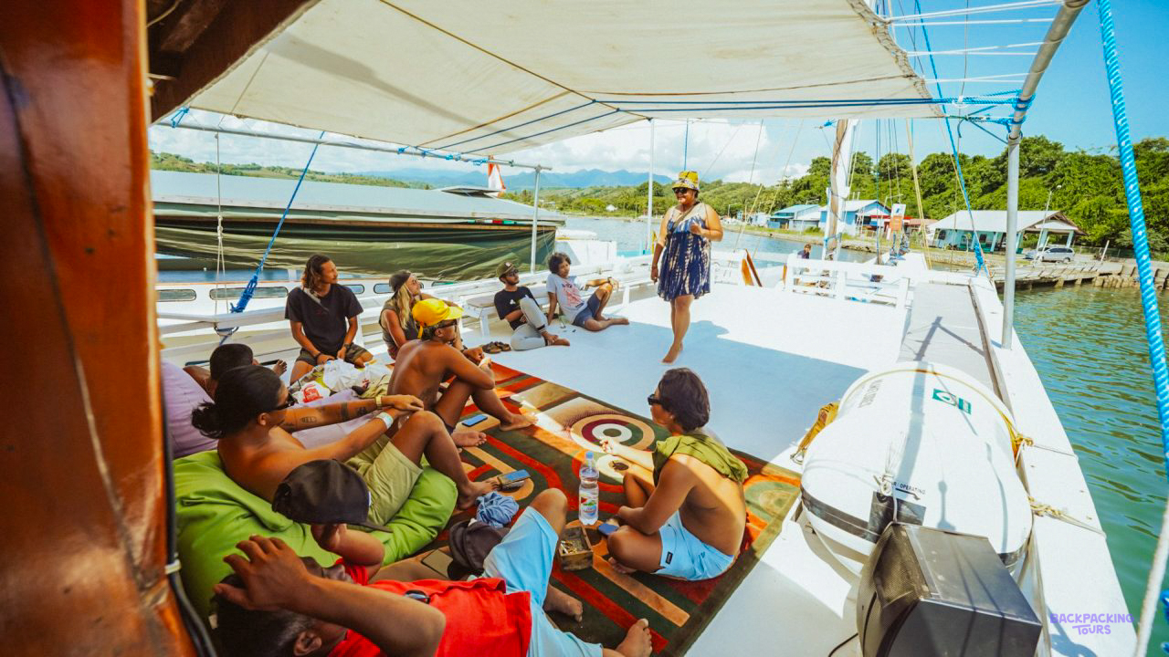 Travellers relaxing on cushions on the shaded deck of the liveaboard boat