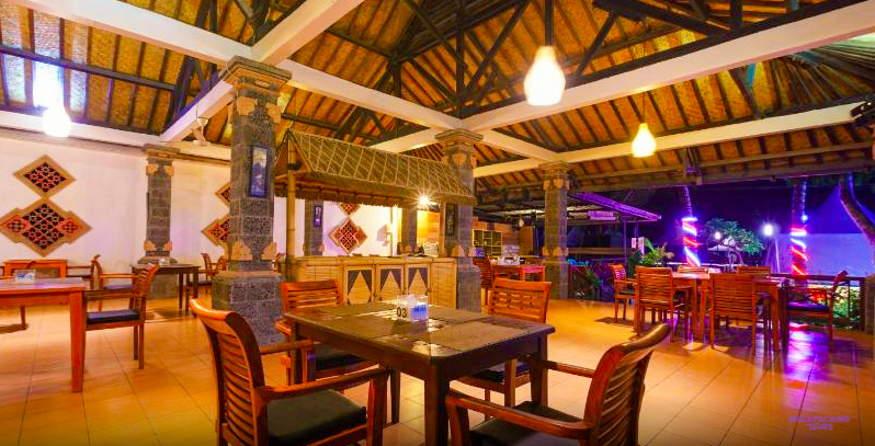 The lit-up restaurant and bar under a thatched roof at the Lombok bungalows