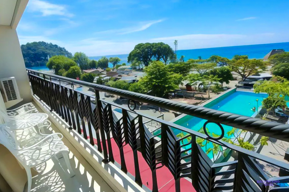 The view from a balcony at the hotel in Padang, over the pool and trees to the sea