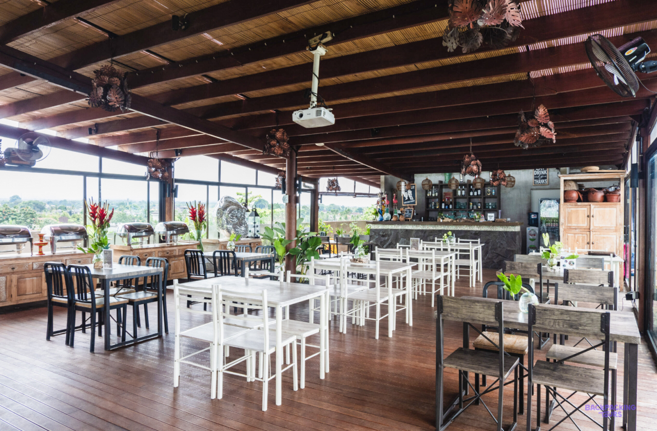 The open-sided restaurant with white tables at the hotel in Ubud
