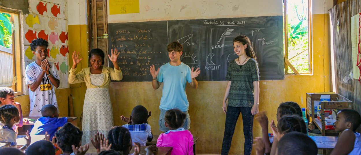Volunteers and local teachers engage children in a lively classroom activity in Madagascar.