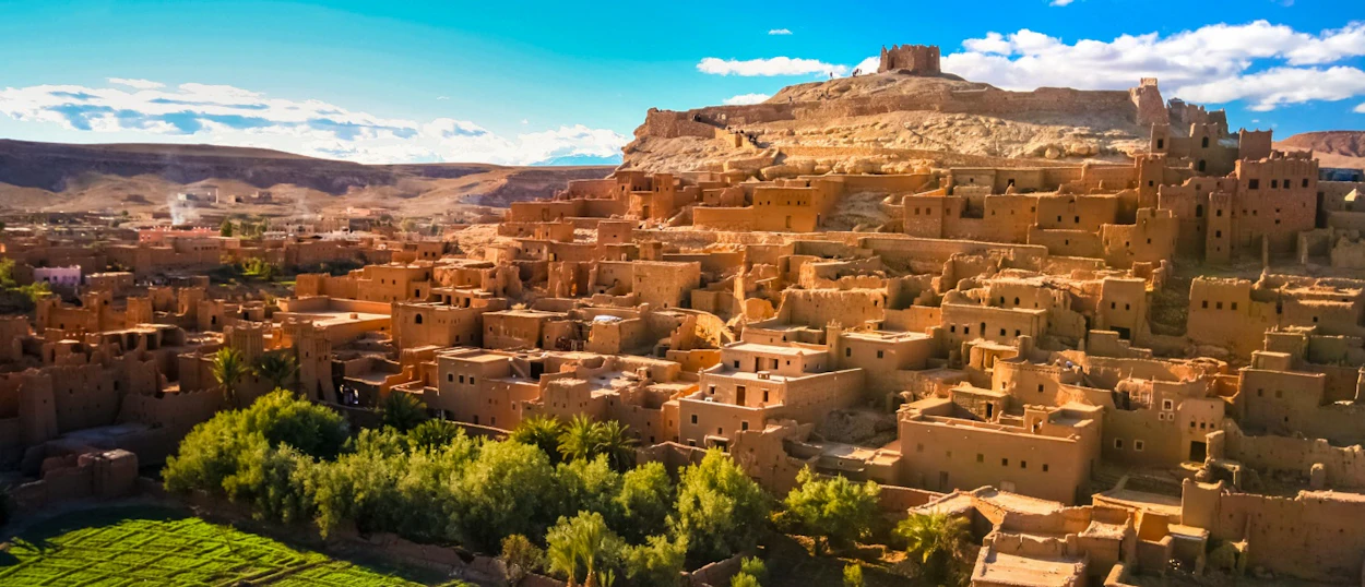 Ancient fortified village of Ait Ben Haddou with mud-brick homes nestled against a desert hill.