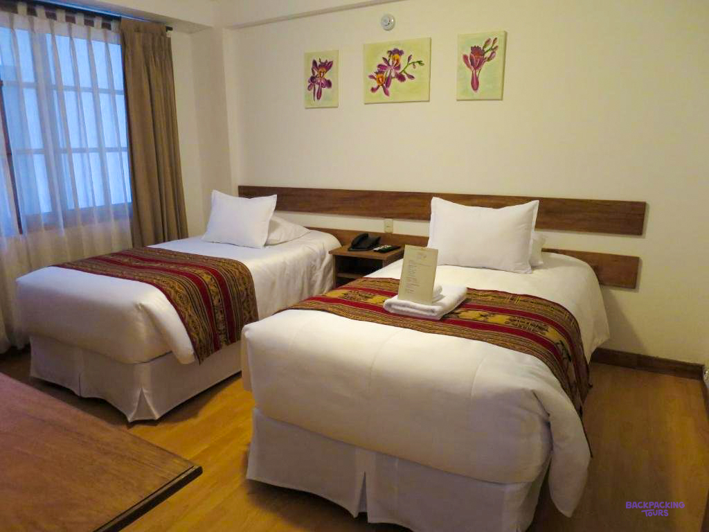 A twin room with woven bedspreads and a wooden headboard at the hotel in Aguas Calientes