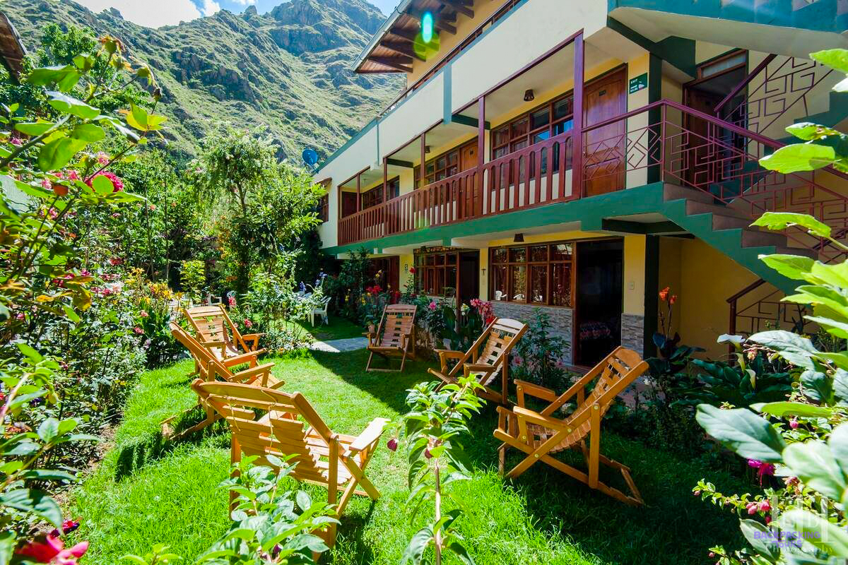 The hotel garden in Ollantaytambo, with wooden sun chairs on the lawn below the balconies and mountains