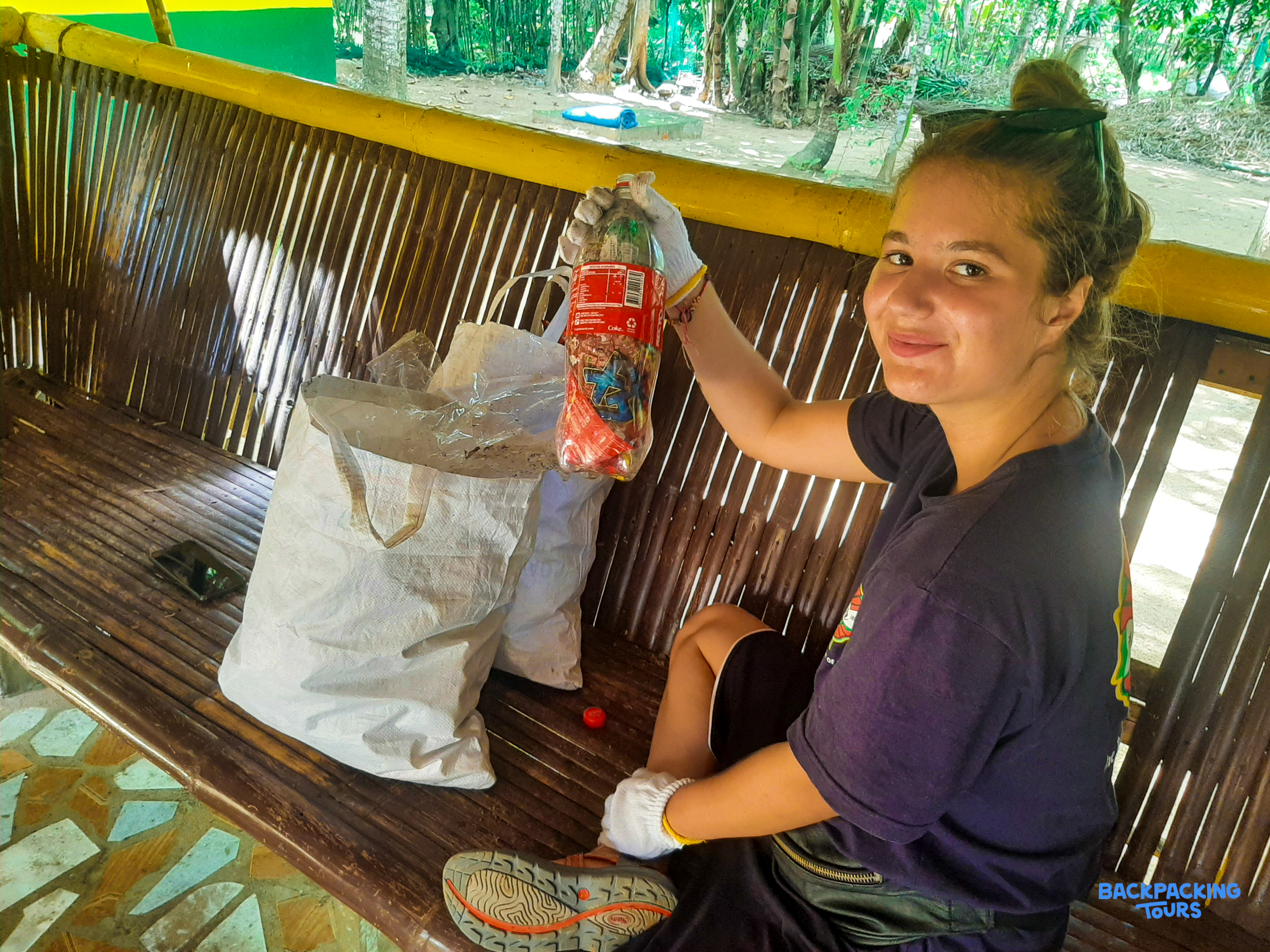 A volunteer smiles, proudly holding collected plastic waste during a cleanup activity in the Philippines.