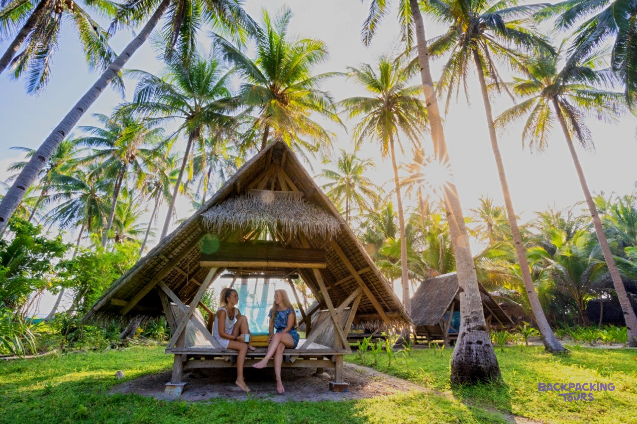 A traditional Filipino beach hut with a thatched roof on a remote island.