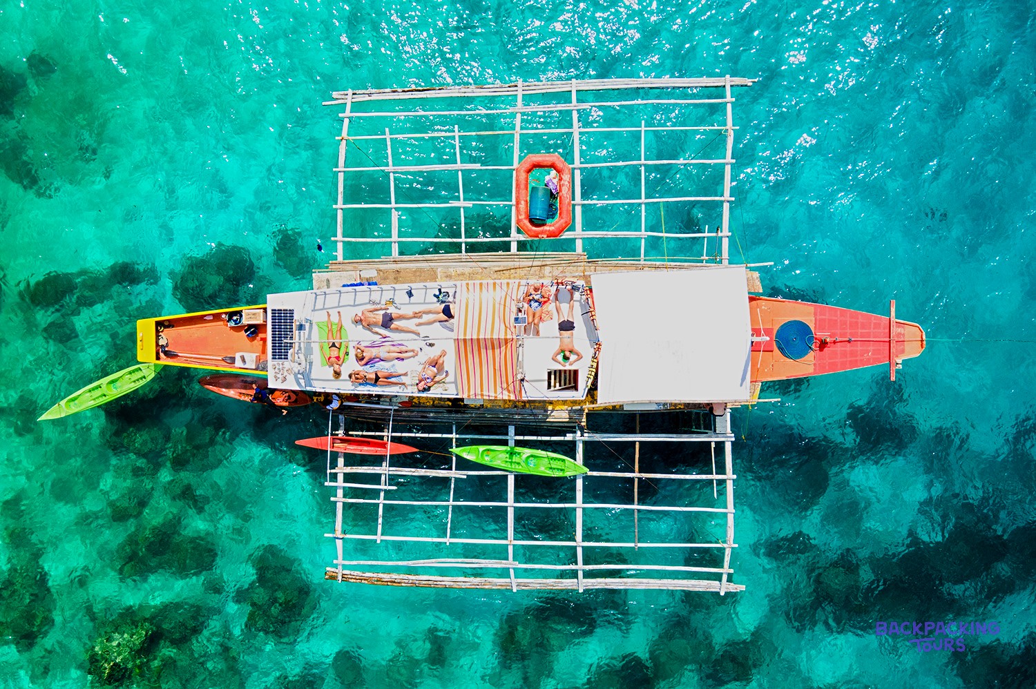 Travellers relaxing on the roof of a traditional Banca boat in Palawan.