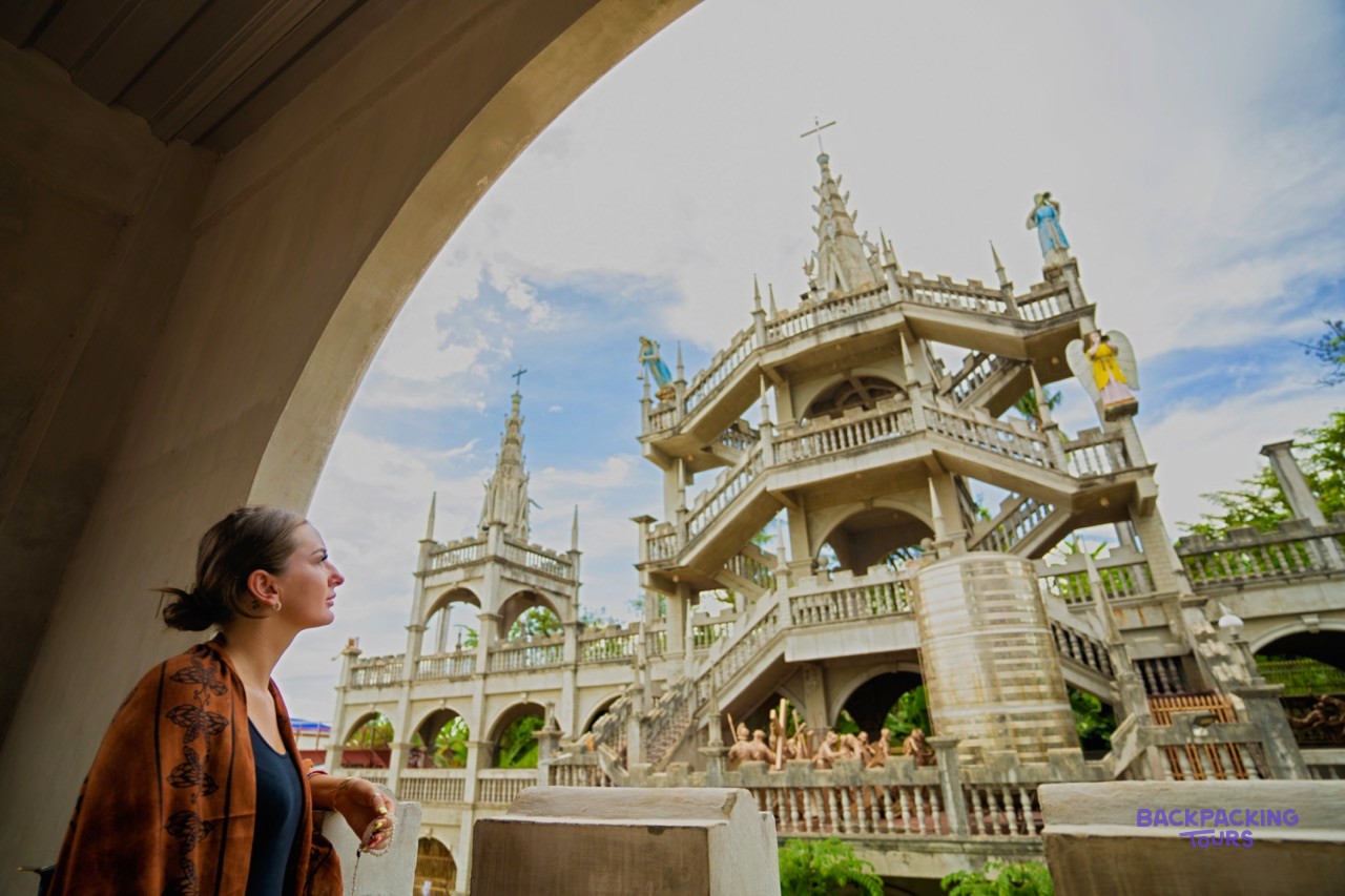 Travellers exploring the ornate grounds of Simala Church in Cebu.