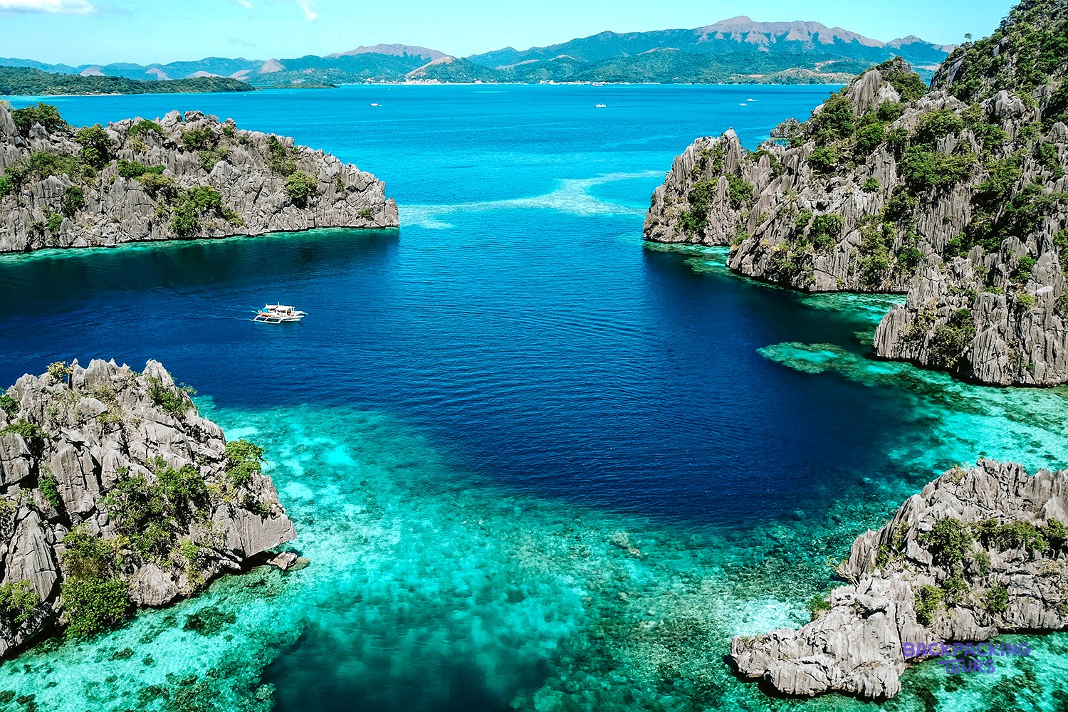An aerial view of limestone karst islands and turquoise lagoons around Coron.