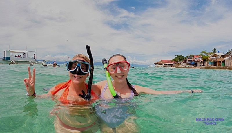 Snorkellers swimming in the bright turquoise water of Coron in the Philippines.