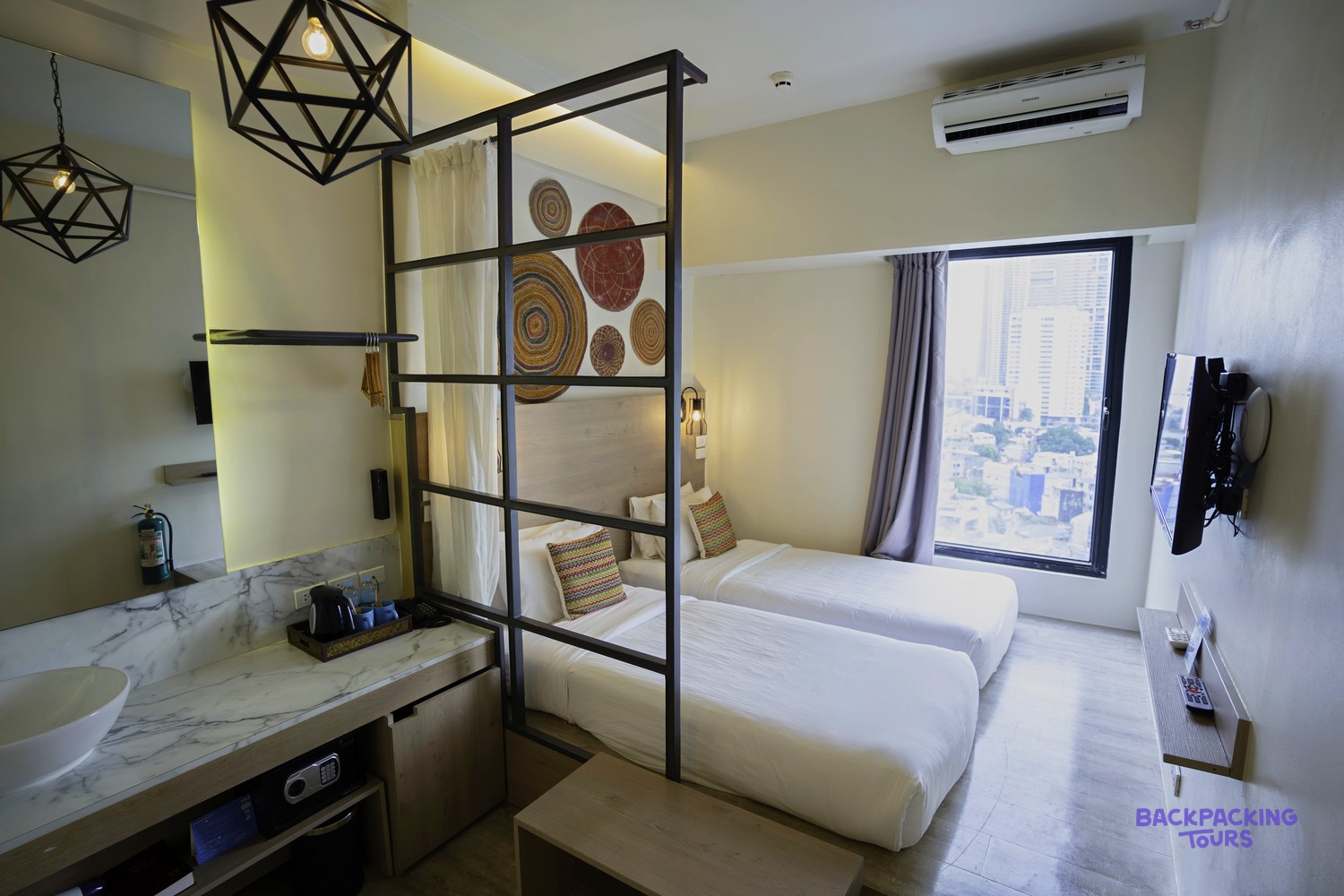 A bright twin room at Lub D Hotel in Manila with crisp white bedding.