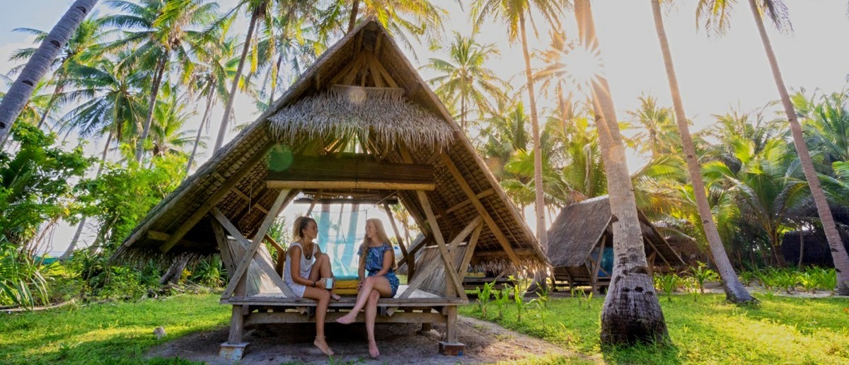 A traditional Filipino beach hut with a thatched roof on a remote island.
