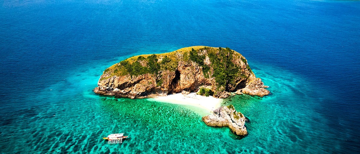 A traditional Banca boat anchored off a deserted island on the Coron to El Nido expedition.