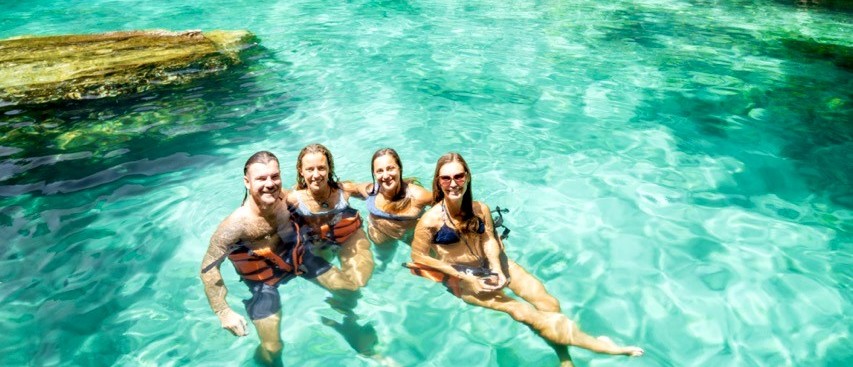A group of travellers swimming together in a hidden lagoon in Palawan.