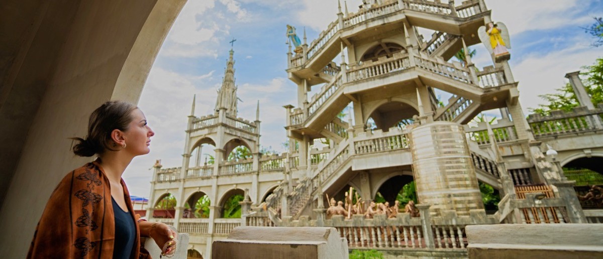 Travellers exploring the ornate grounds of Simala Church in Cebu.