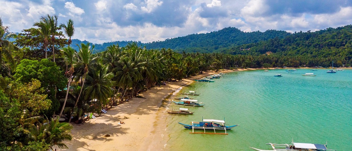 The quiet palm-lined beach at Port Barton in southern Palawan.