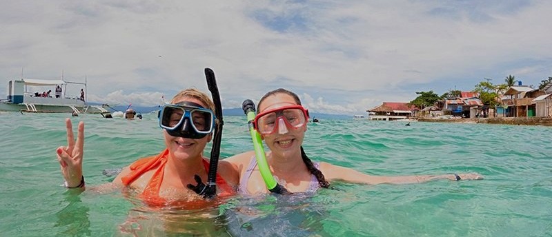 Snorkellers swimming in the bright turquoise water of Coron in the Philippines.