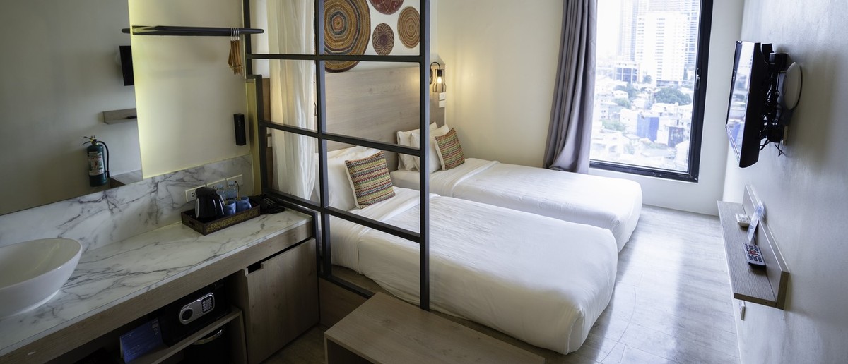 A bright twin room at Lub D Hotel in Manila with crisp white bedding.