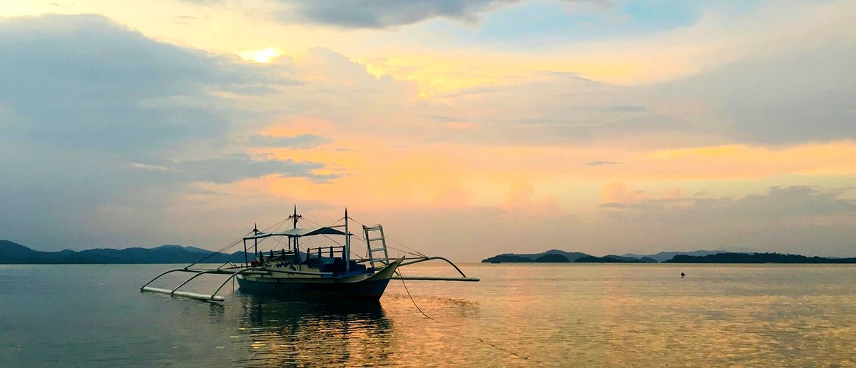 Travellers on an island hopping boat trip in the clear waters off Port Barton.