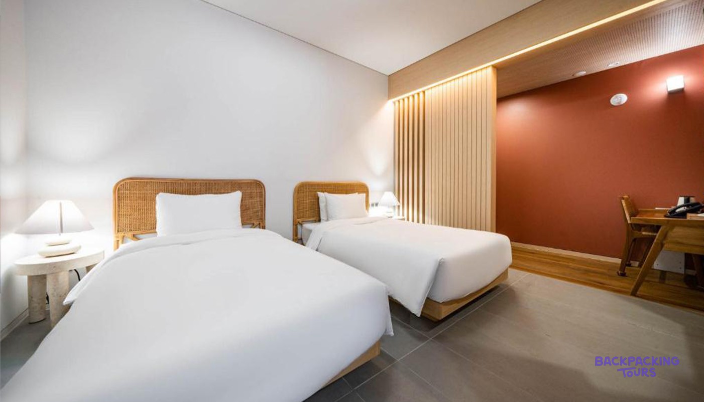 A twin room at the Hound Hotel Haeundae in Busan with woven headboards and white linen.