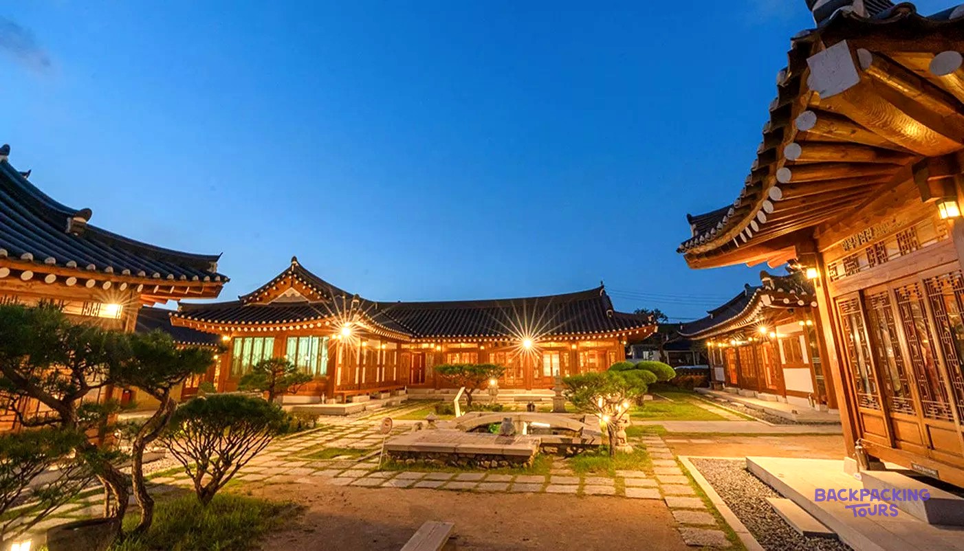 The courtyard of a traditional hanok village in Gyeongju lit up at dusk.