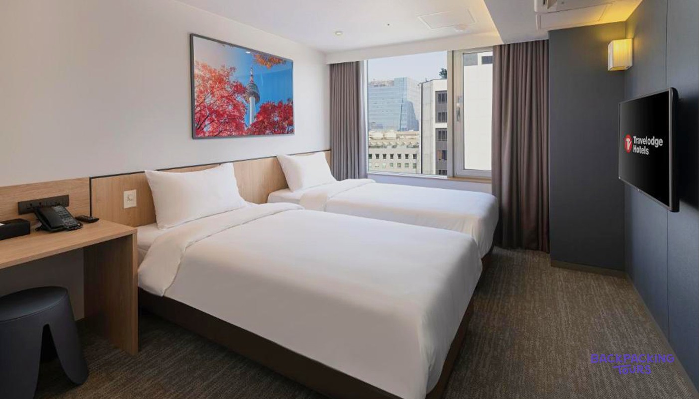 A twin hotel room at the Travelodge Myeongdong Namsan in Seoul with two neatly made beds.