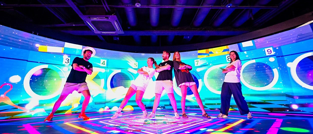 Travellers learning a routine in a neon-lit K-pop dance studio in Seoul.