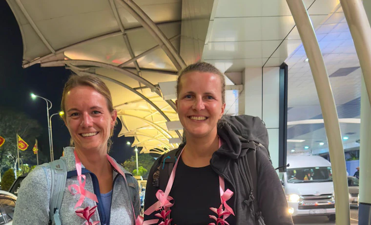 Smiling women with leis and a welcome sign arrive in Colombo for their Sri Lanka tour.