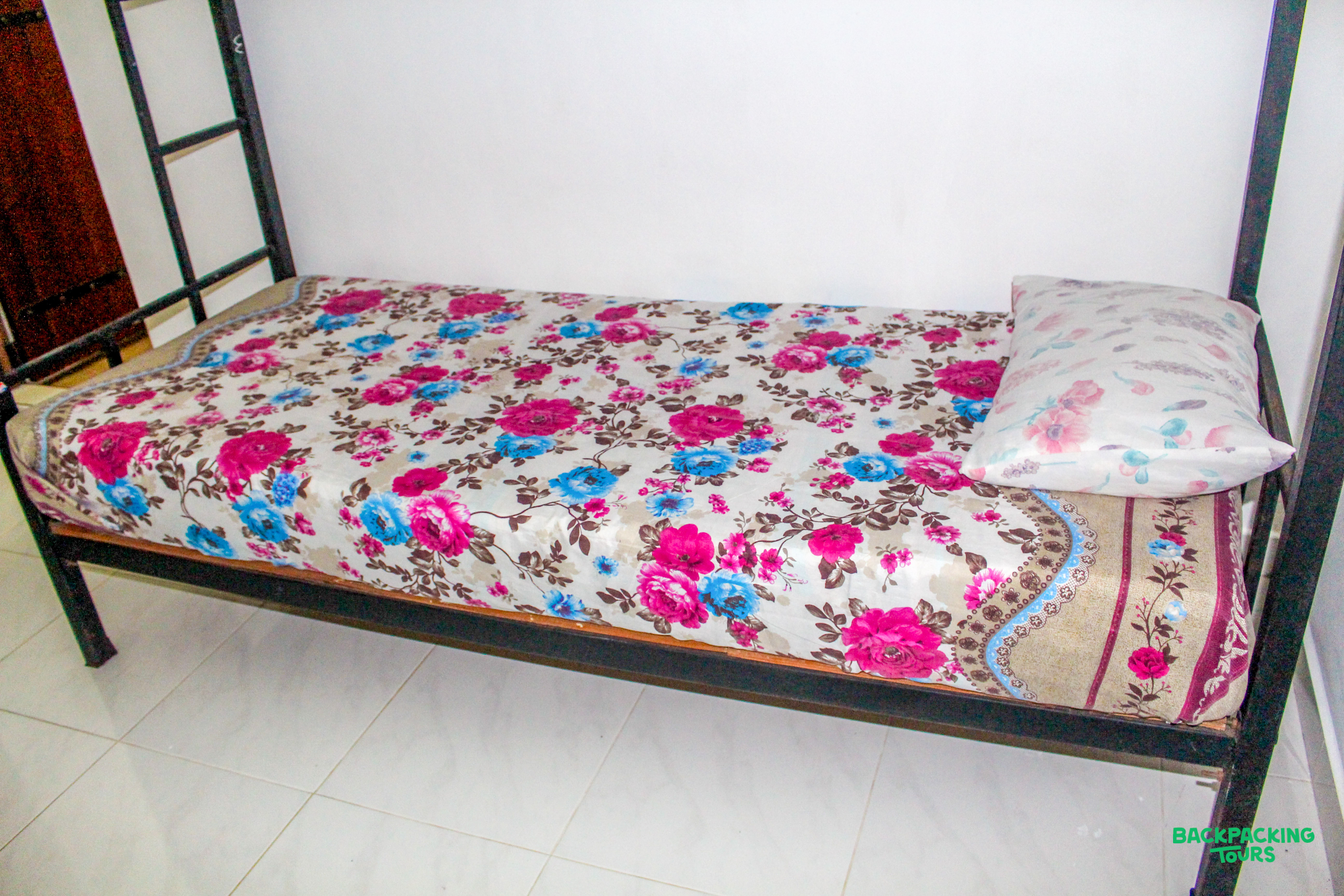 A comfortable bed with vibrant floral bedding in your charming Sri Lankan accommodation.