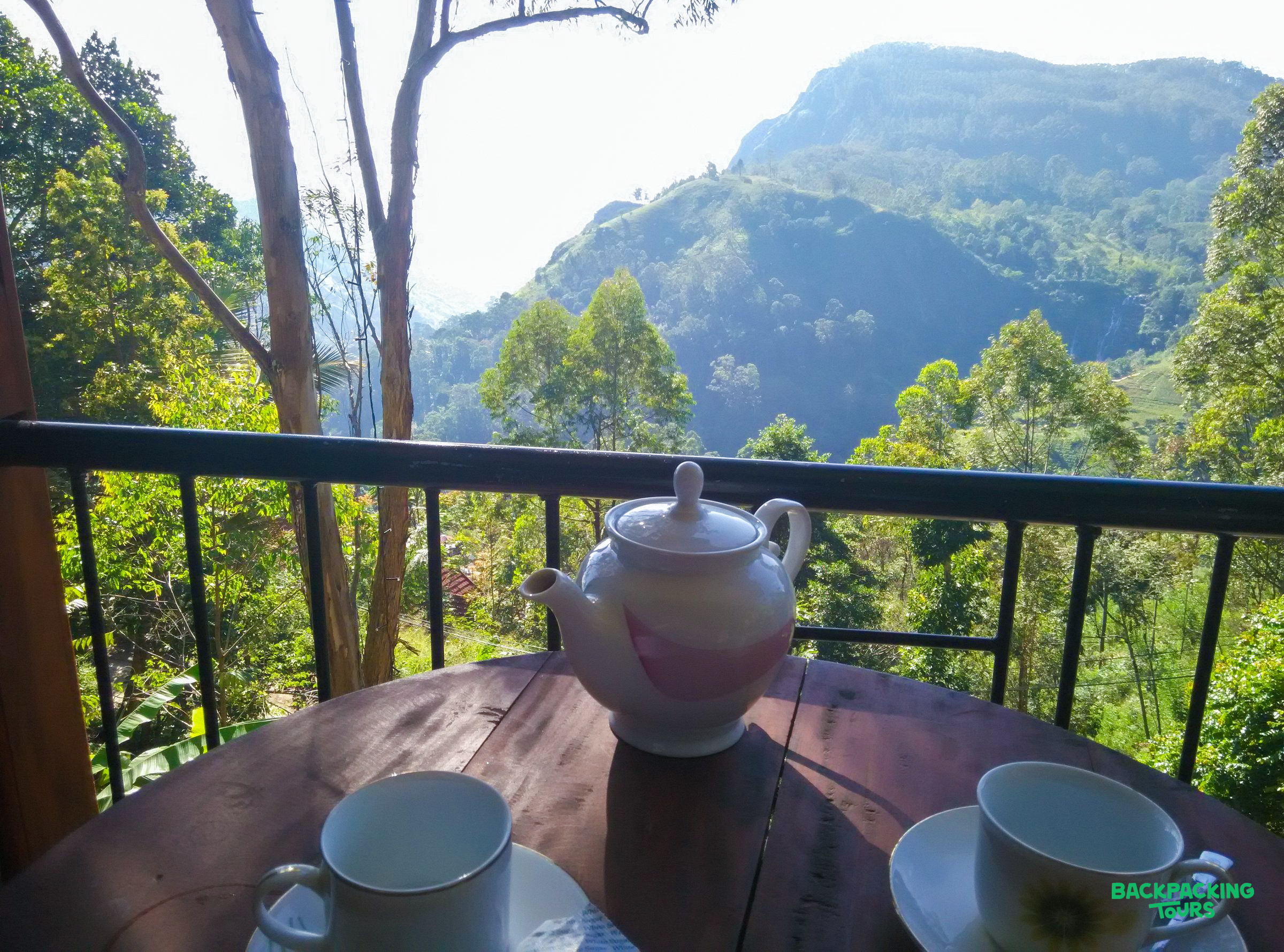 Enjoying tea on a balcony overlooking the lush green mountains of Ella, Sri Lanka.