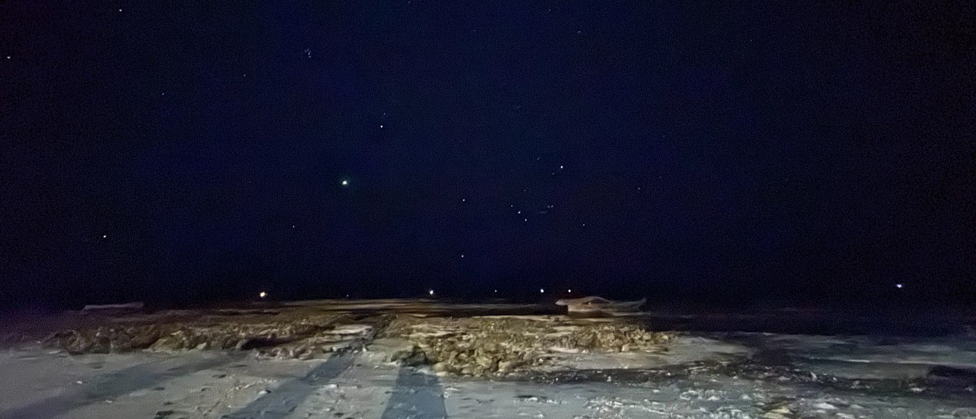 Stars fill the night sky above the pale sand and rocks of the Makunduchi shore.