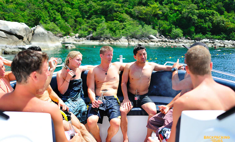 Backpackers on a boat trip, enjoying the beautiful scenery and clear waters of Koh Tao.