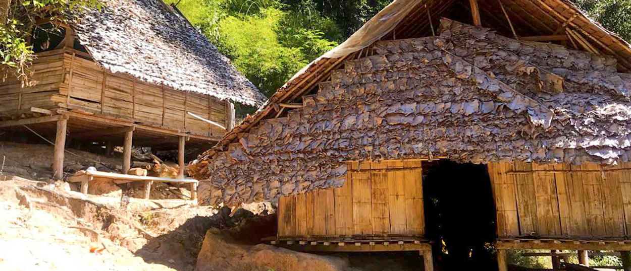 Traditional bamboo huts with thatched roofs in a hill tribe village near Chiang Mai, Thailand.