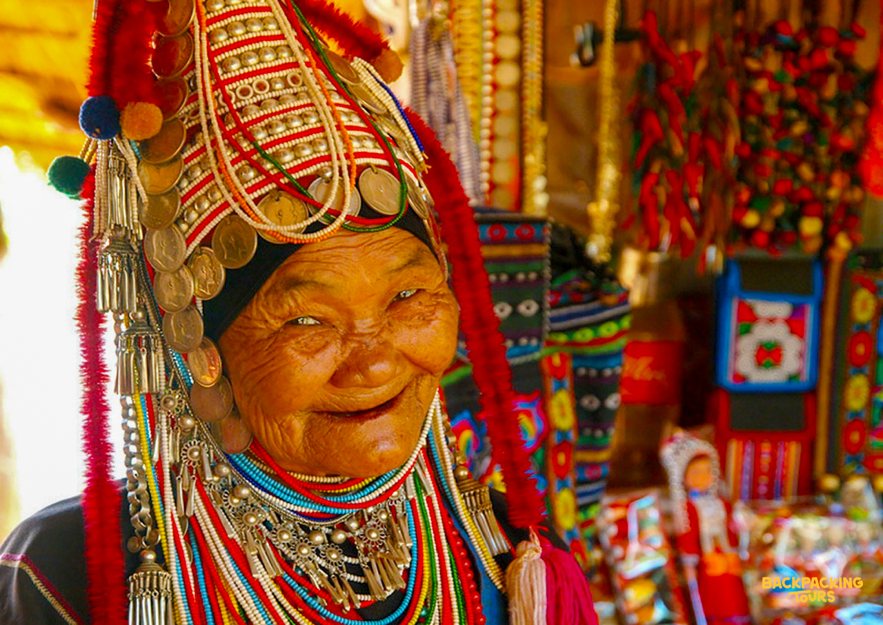 Hill tribe woman in colorful beaded headdress during backpacking tour's jungle trek