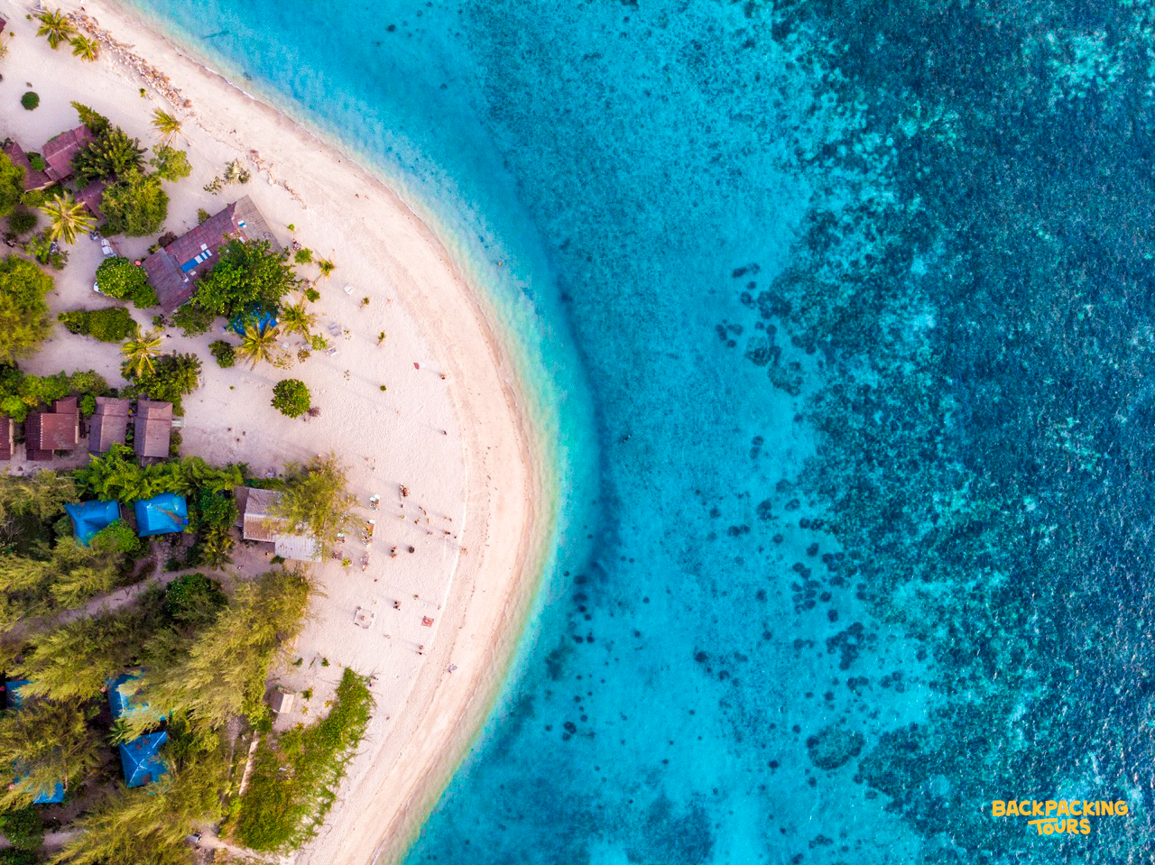 Aerial drone view of Koh Phangan's coastline with turquoise water and lush greenery during the island hopping day