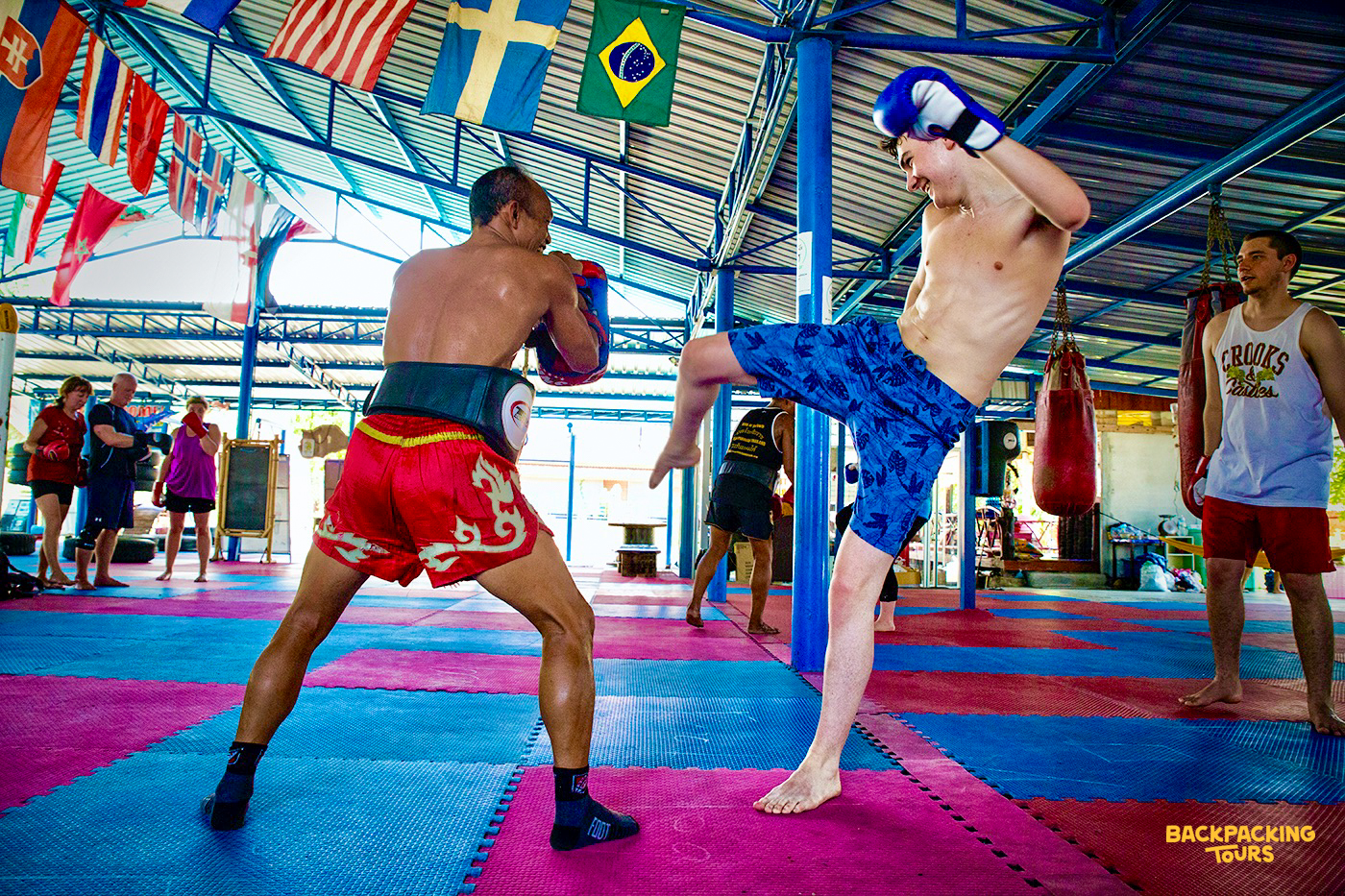 Practicing Muay Thai boxing in a local gym with trainers during the backpacking tour's optional activity day
