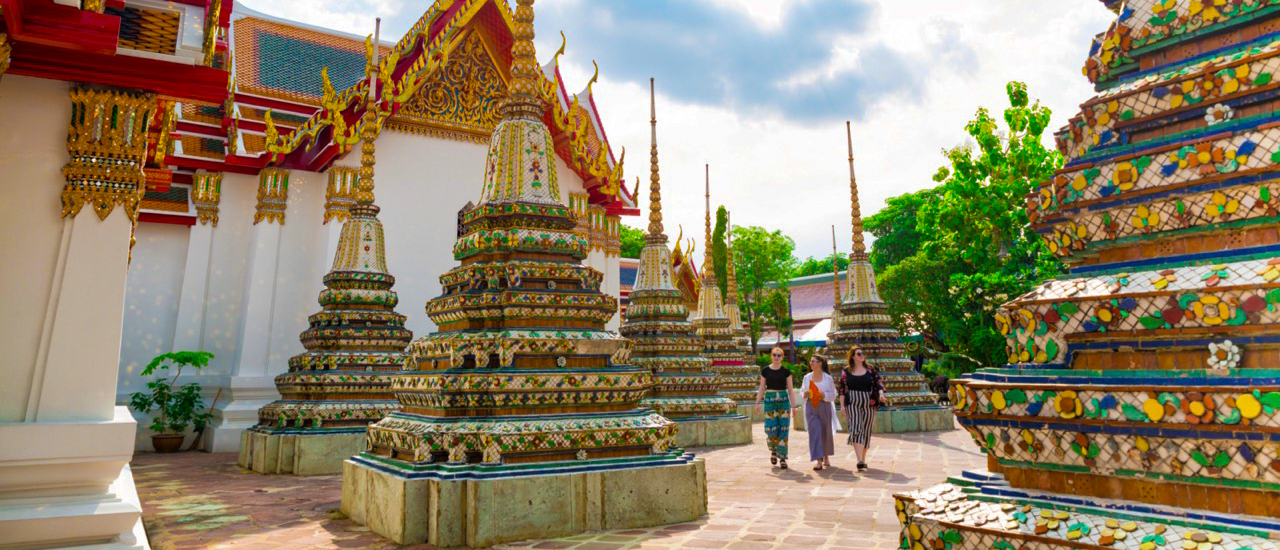 Backpacking group visiting Wat Pho temple in Bangkok on tuk tuk tour