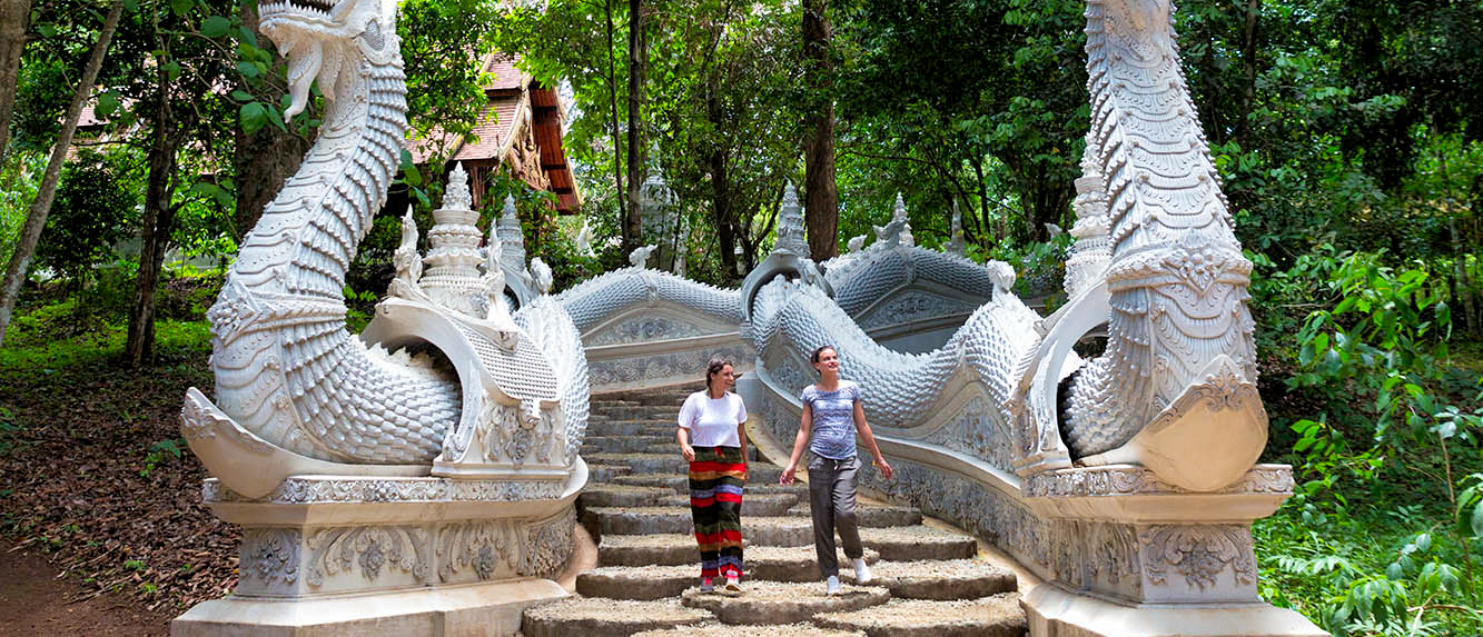 Backpacking tour exploring ornate serpent staircase at Wat Phra That Doi Suthep temple in Chiang Mai