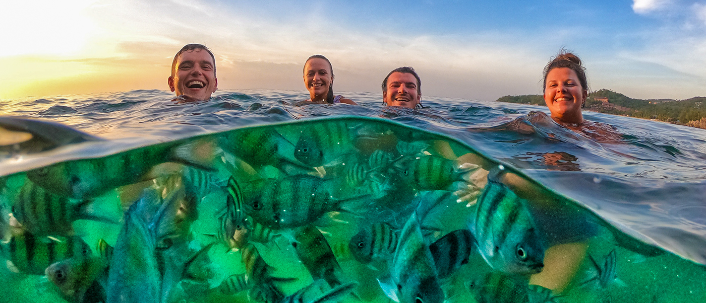 Backpacking tour friends swimming and snorkeling in clear waters around Koh Phangan during island tourAerial view of hidden beach and turquoise waters on Koh Phangan during island tour for backpacking groupAerial view of hidden beach and turquoise waters on Koh Phangan during island tour for backpacking group