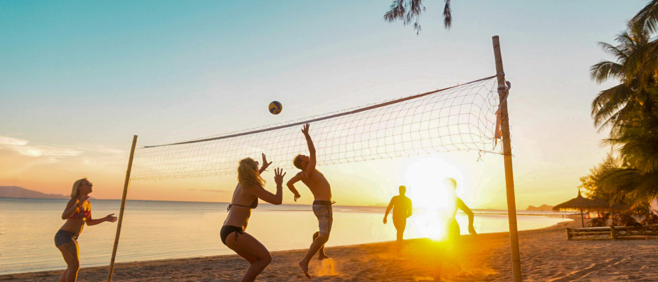 Backpacking tour friends playing beach volleyball at Koh Phangan during beach dayBackpacking tour friends swimming and snorkelling in the clear waters around Koh Phangan during island tour