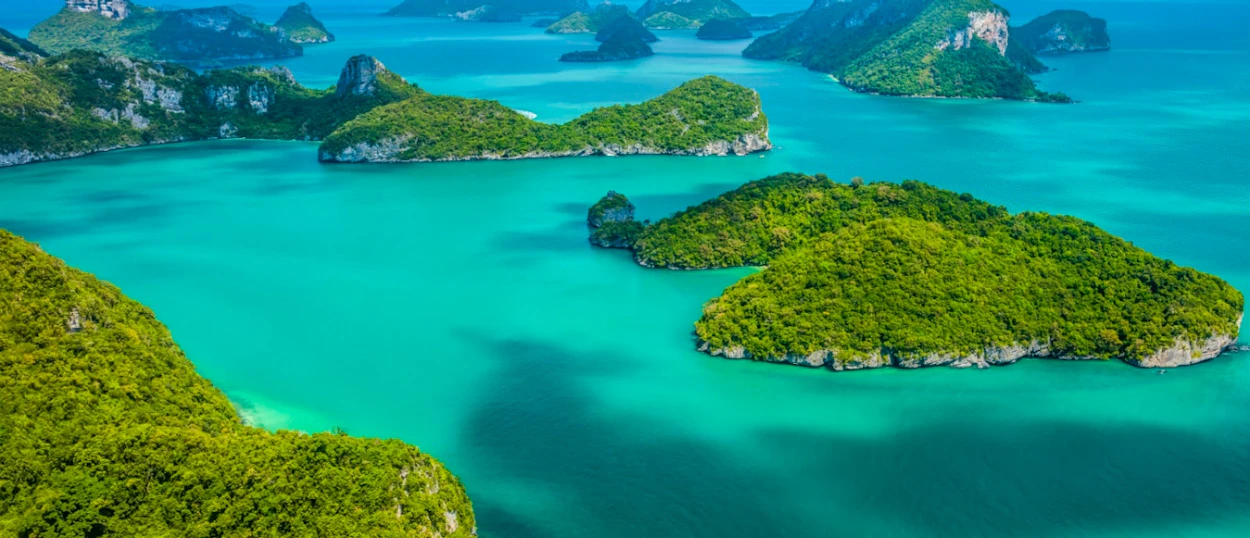Lush green tropical islands rise from the vibrant turquoise waters of Ang Thong National Marine Park.