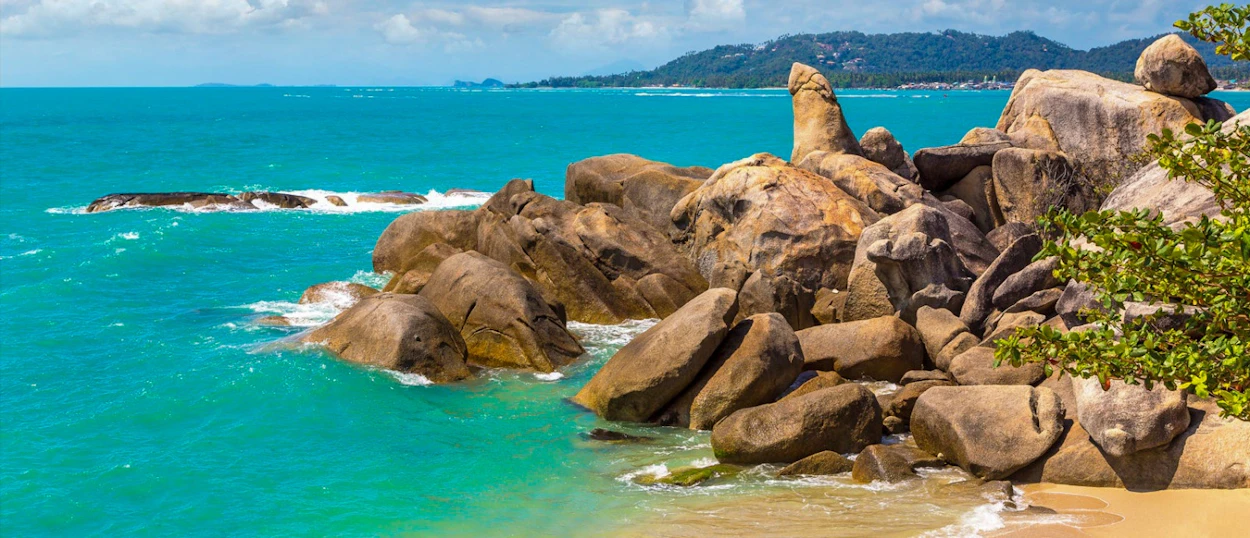Unique Hin Ta rock formation on a sandy beach with vibrant turquoise water in Koh Samui.