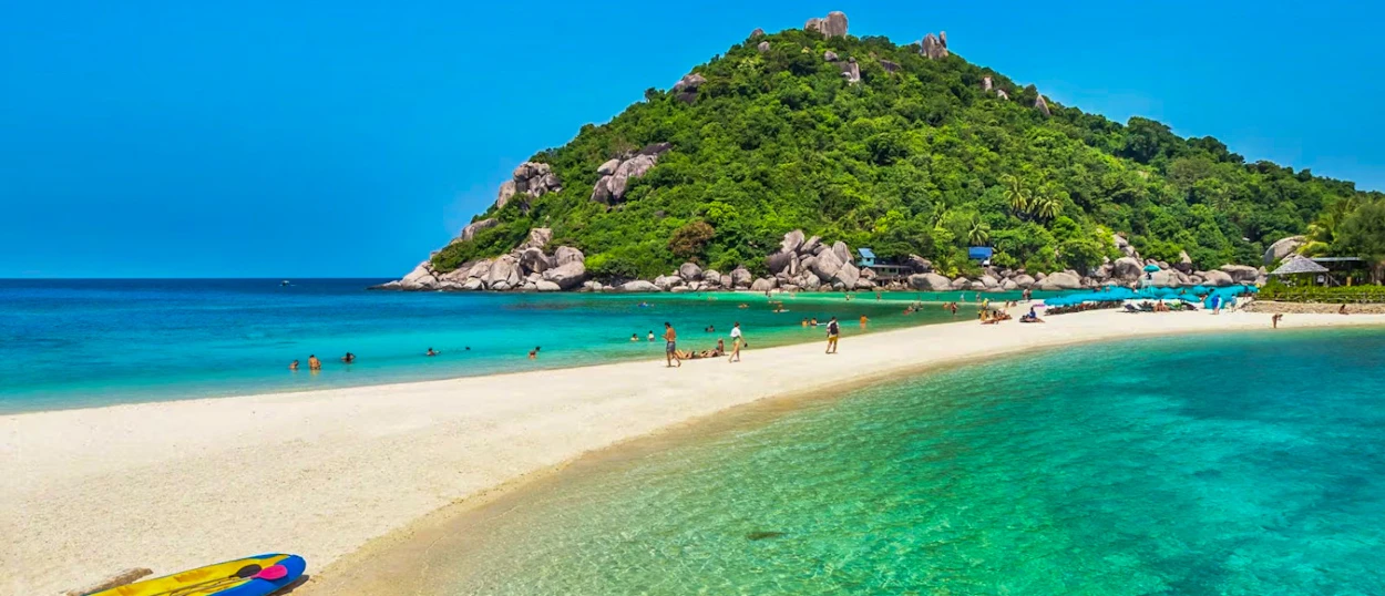 Visitors enjoy the pristine white sandbar and clear turquoise waters connecting lush islands at Koh Nang Yuan.