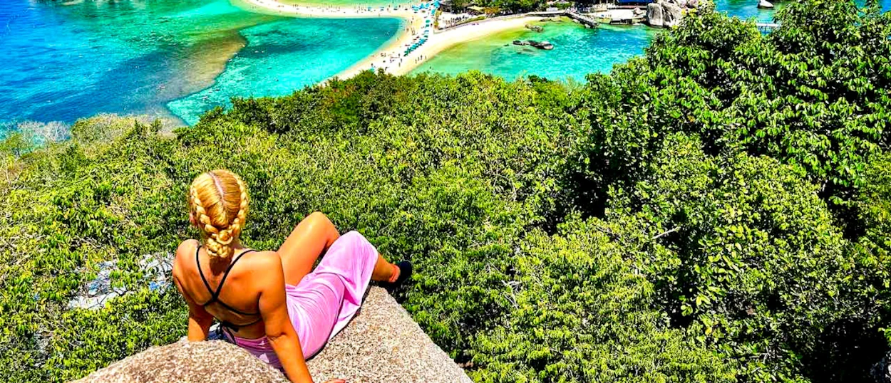A woman with braided hair admires the iconic turquoise waters and sandbar of Koh Nang Yuan.