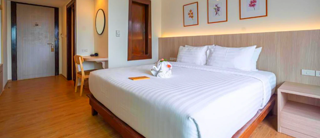 Inviting hotel room in Phuket with a king-size bed, white linens, and a charming towel animal.