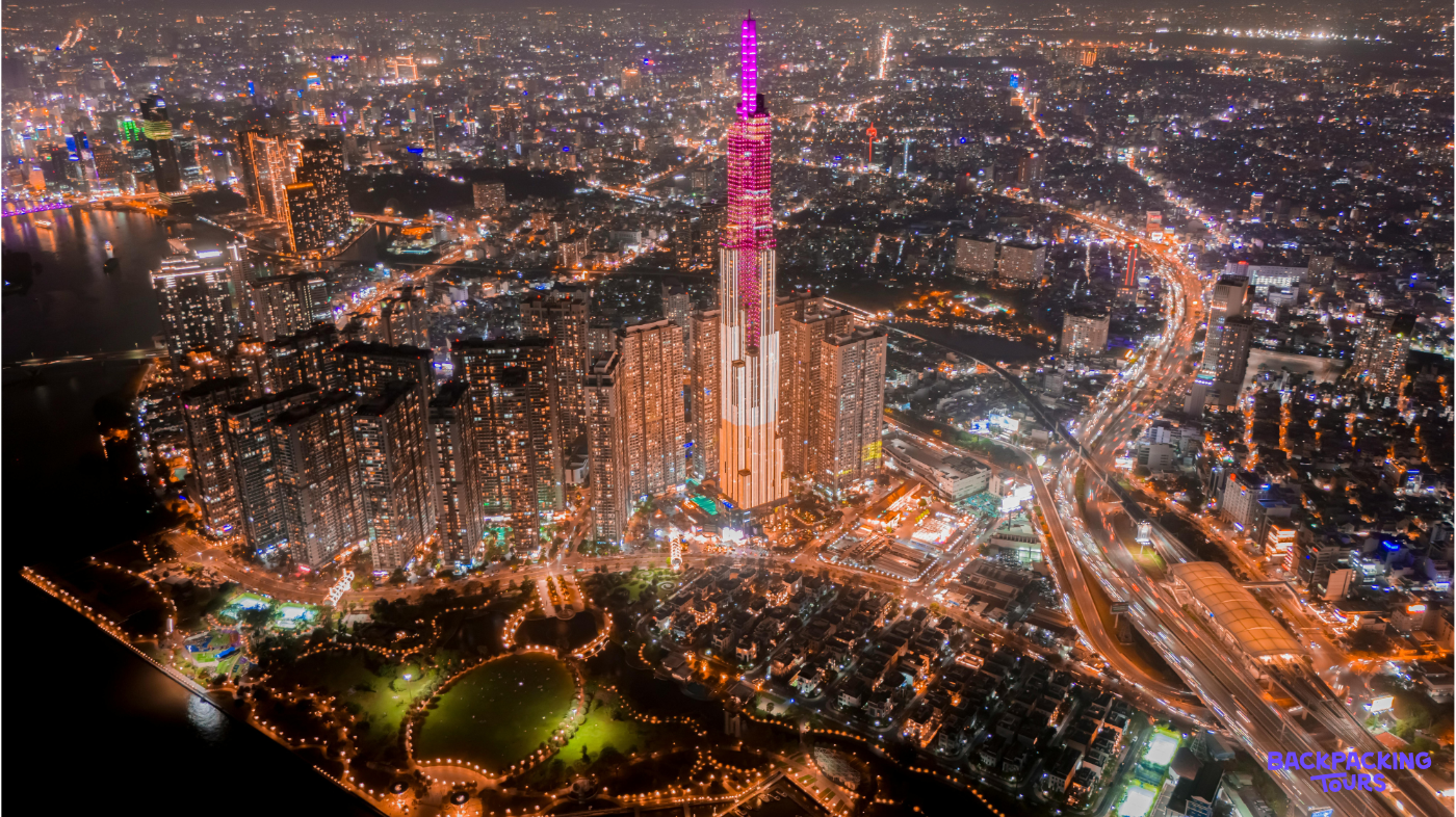 Ho Chi Minh City's dazzling night skyline, with a prominent skyscraper glowing pink above busy streets.
