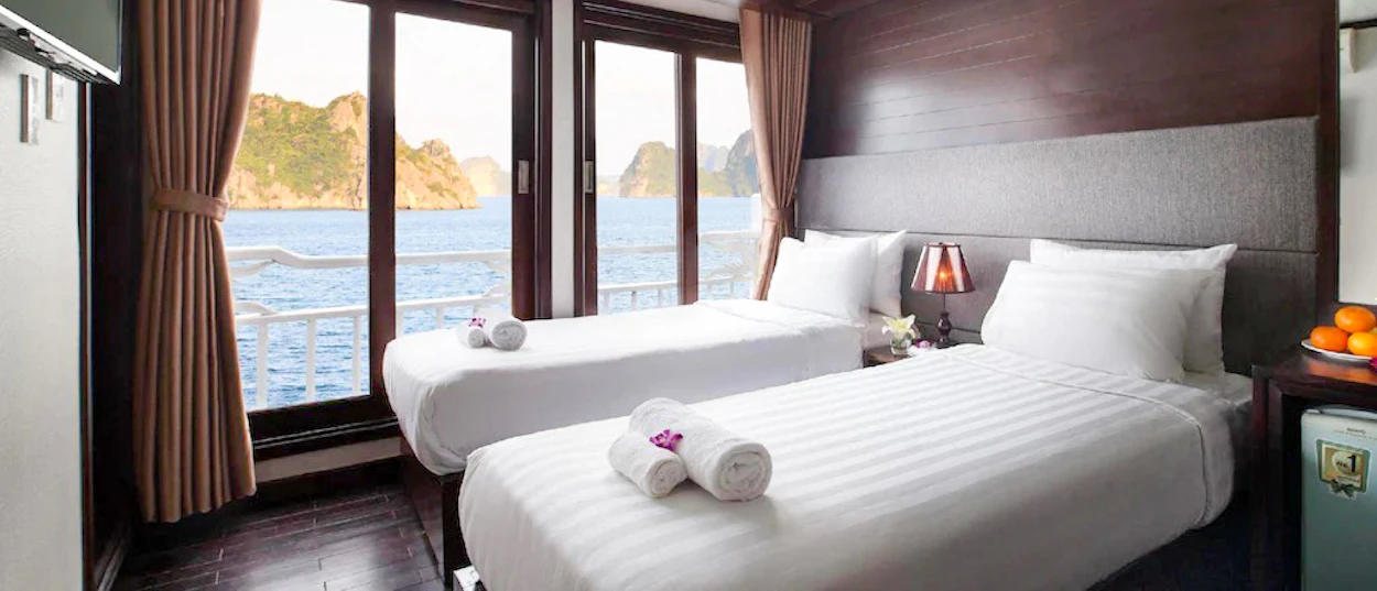 A comfortable twin cabin on a cruise boat with a stunning view of Ha Long Bay.