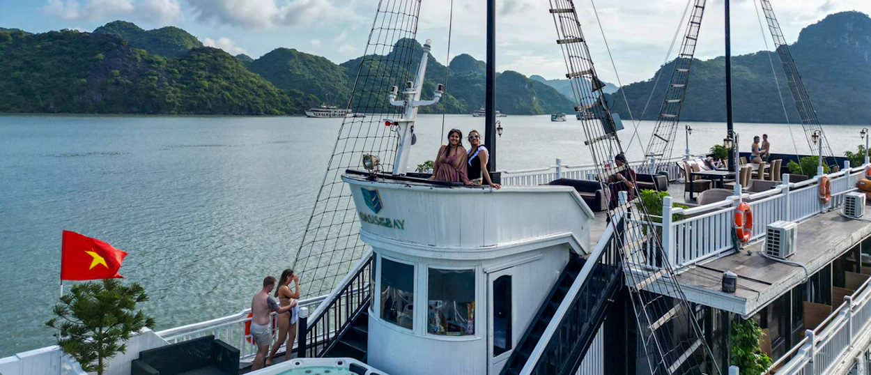 Relaxed tourists on a cruise boat enjoying the scenic limestone karsts of Ha Long Bay, Vietnam.