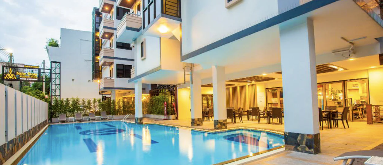 An inviting hotel swimming pool and illuminated outdoor seating area, perfect for relaxing in Bangkok.