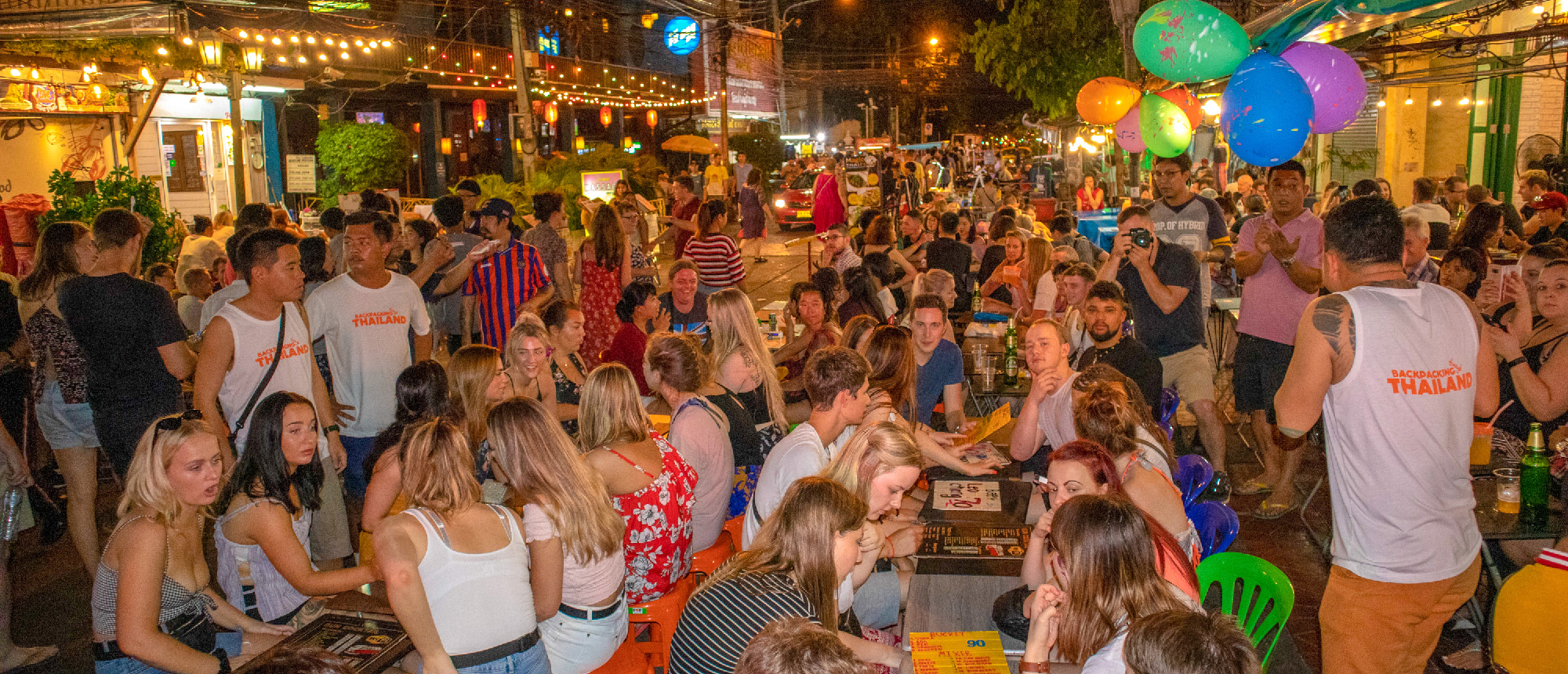Backpacking group celebrating at a welcome dinner on Khao San Road in Bangkok